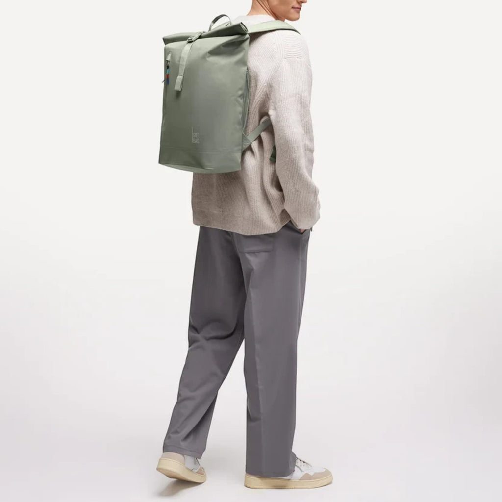 Lieblingstasche GOT BAG Rolltop Lite 2.0 sage green backpack worn by a man in a casual sweater and trousers