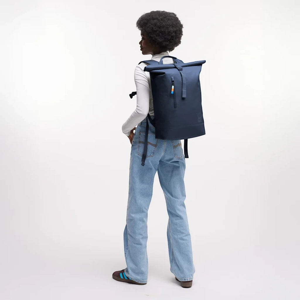 Lieblingstasche GOT BAG Rolltop Lite 2.0 navy blue backpack worn by a model against a white background