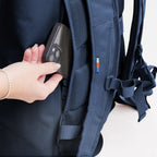Lieblingstasche GOT BAG Rolltop Lite 2.0 navy blue backpack showing a hand placing a smartphone in the side pocket