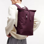 Lieblingstasche GOT BAG Rolltop Lite 2.0 backpack in dark purple worn by a man in a white sweater