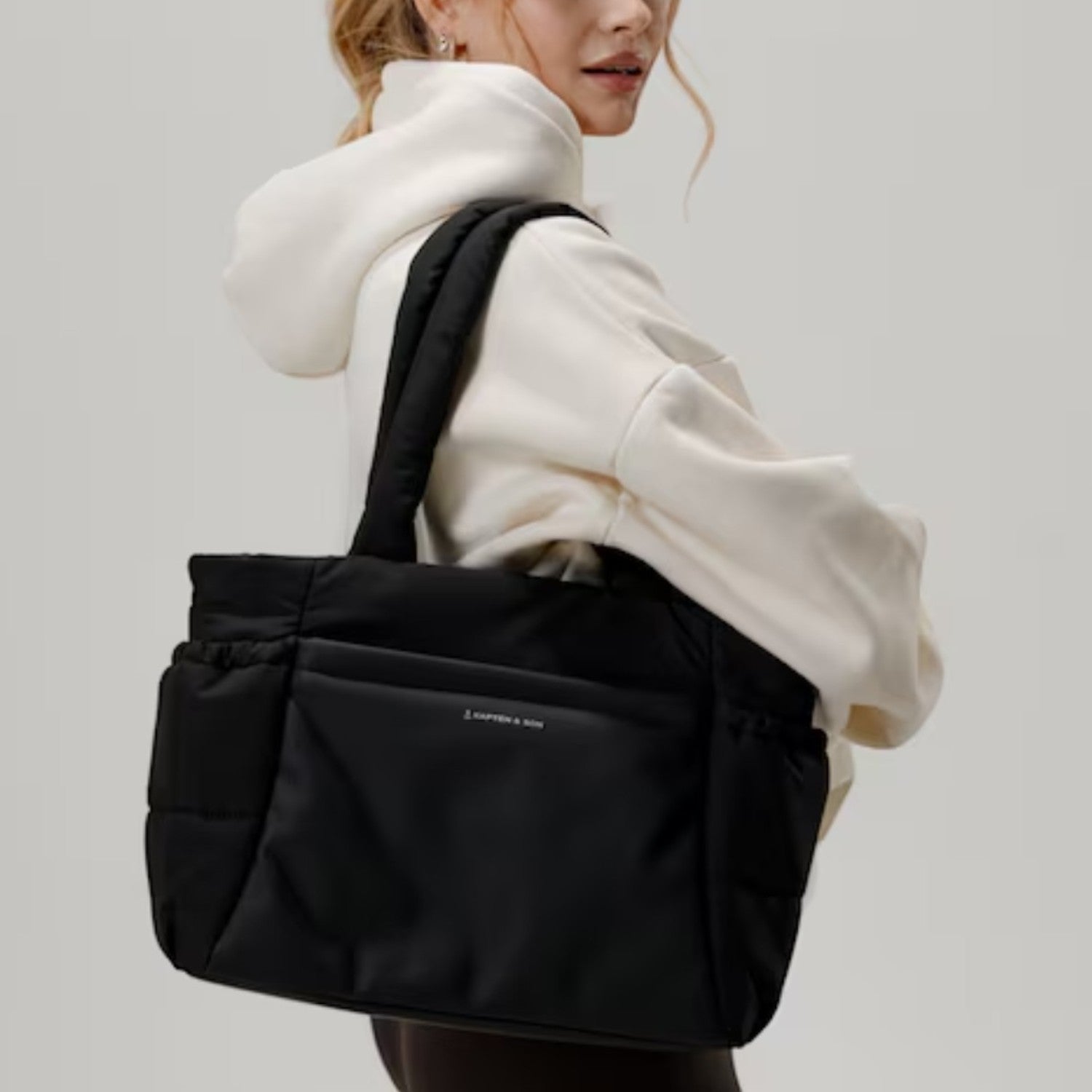 Lieblingstasche Hellvi Cloud Medium black padded tote bag with laptop compartment worn by a woman