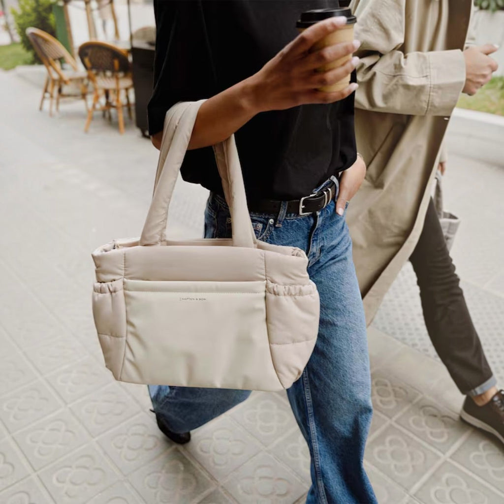 Lieblingstasche Hellvi Cloud Medium beige quilted tote bag with laptop compartment carried by a woman on the street