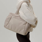 Lieblingstasche Hellvi Cloud Medium tote bag in beige with quilted padding, side bottle pockets, and laptop sleeve.