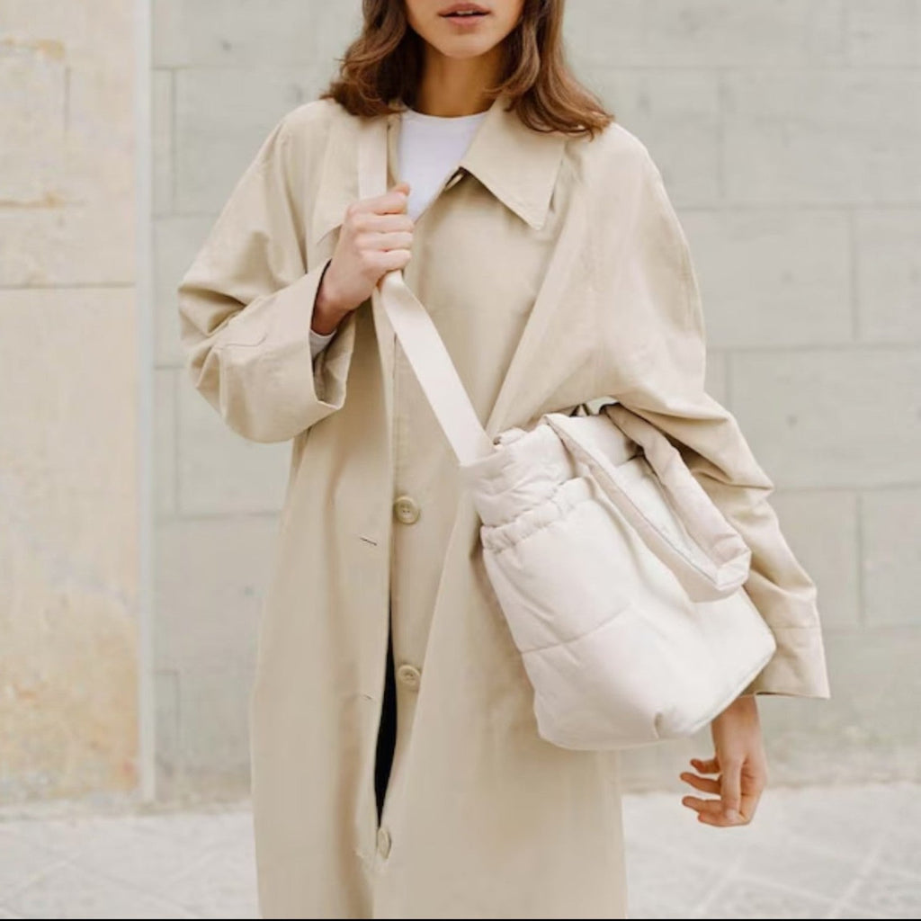Lieblingstasche Hellvi Cloud Medium bag in cream with padded design worn by a woman in a beige trench coat