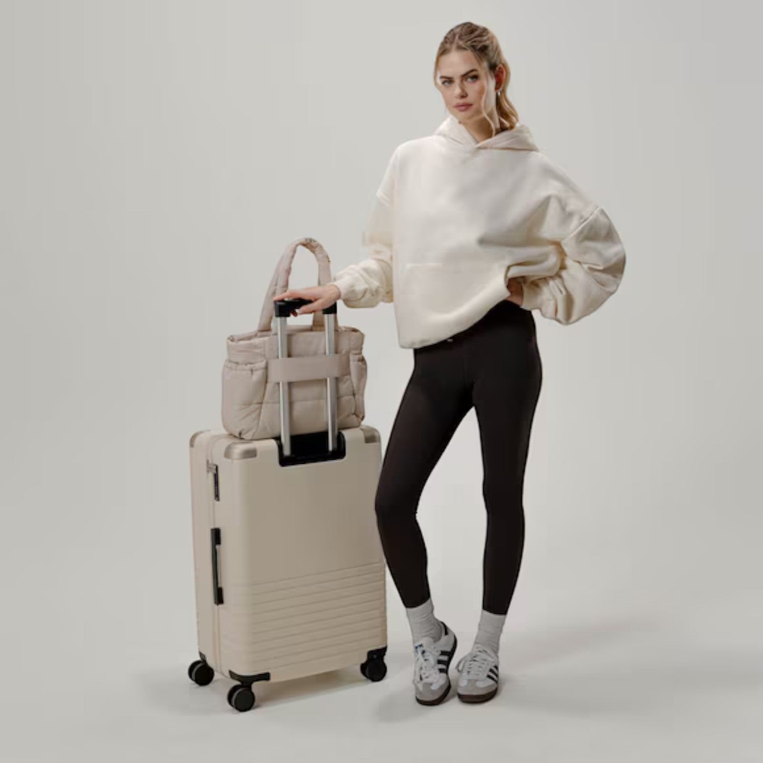 Lieblingstasche Hellvi Cloud Medium beige quilted bag on a suitcase with a model in casual sportswear