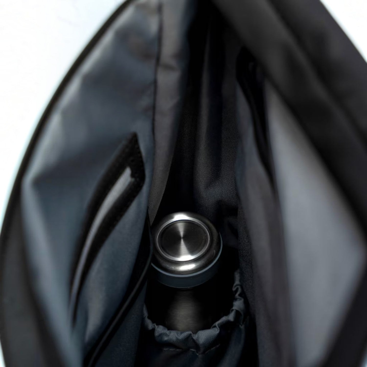 Lieblingstasche Helsinki backpack interior featuring a dedicated grey fabric bottle holder and dark lining