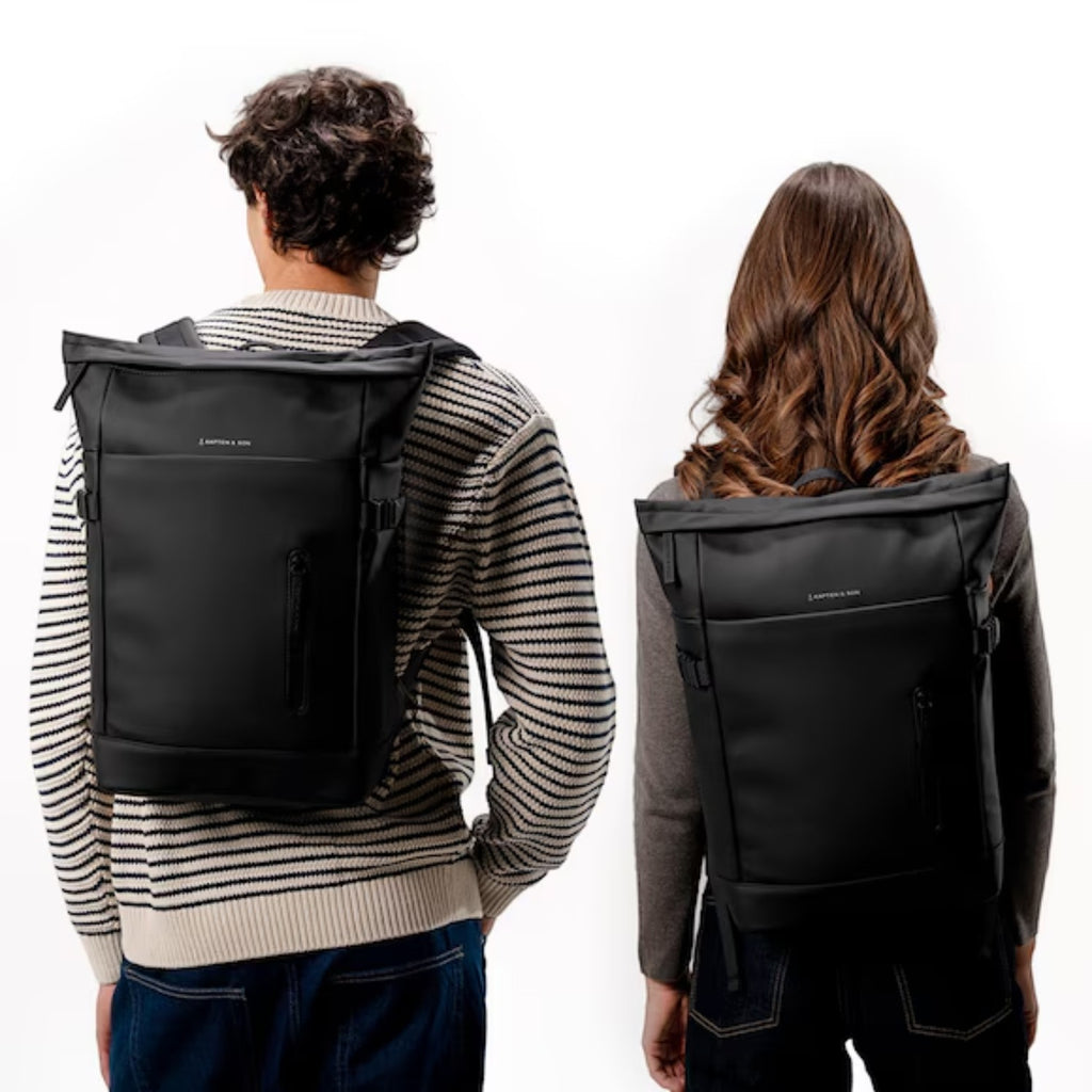 Lieblingstasche Helsinki black rolltop backpack worn by a man and a woman against a white background