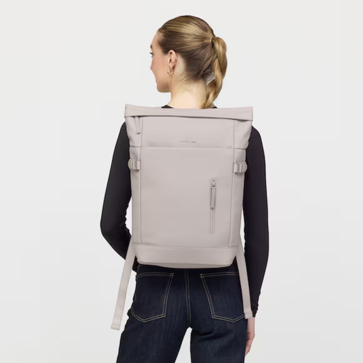 Lieblingstasche Helsinki rolltop backpack in light grey worn by a woman against a plain background