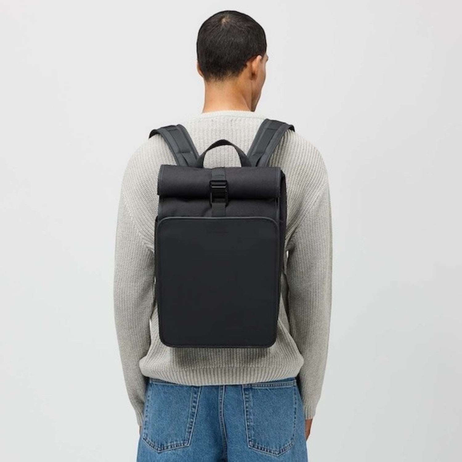 Lieblingstasche Kapten & Son Lund Pro rolltop backpack in black worn by a man in a beige sweater