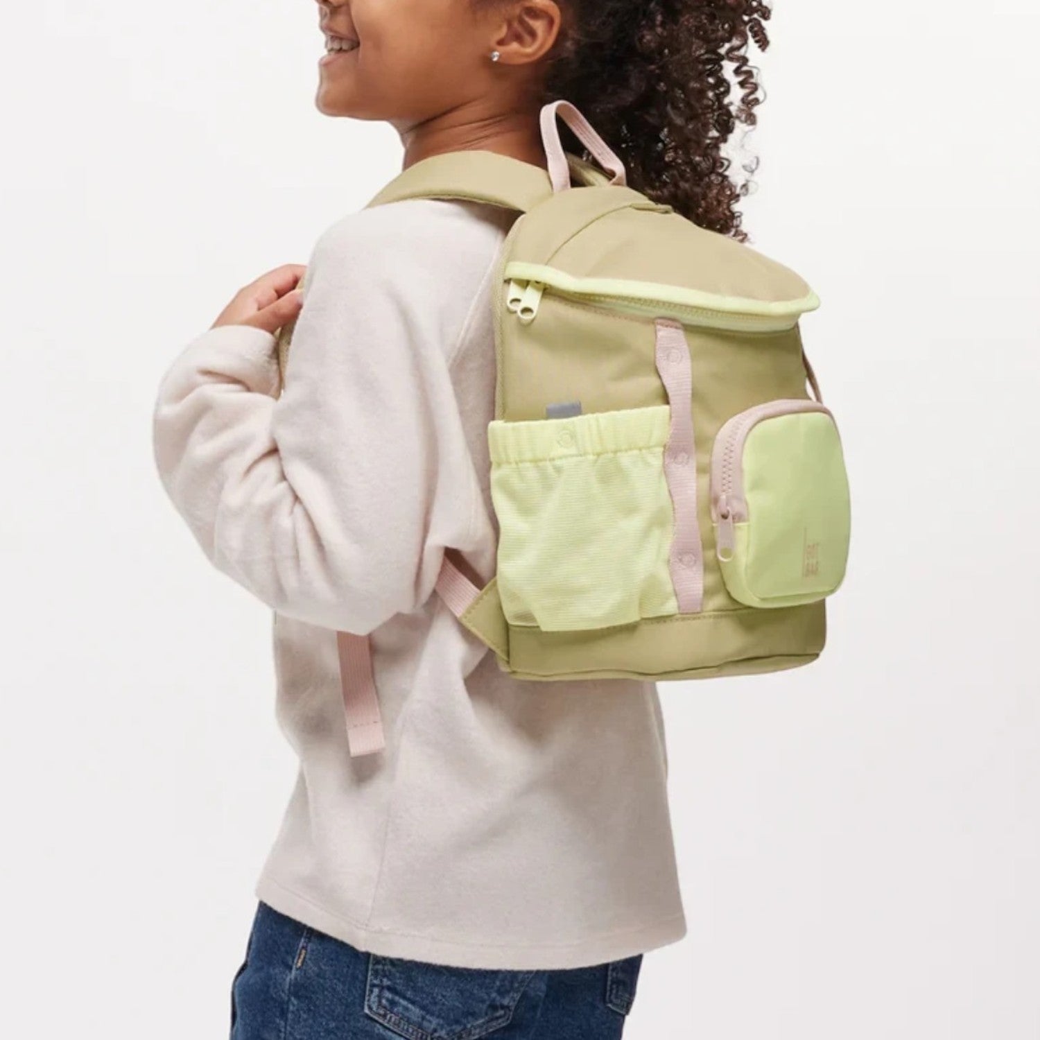 Lieblingstasche kids adventure daypack in olive green and pale pink made from recycled ocean plastic on a young girl