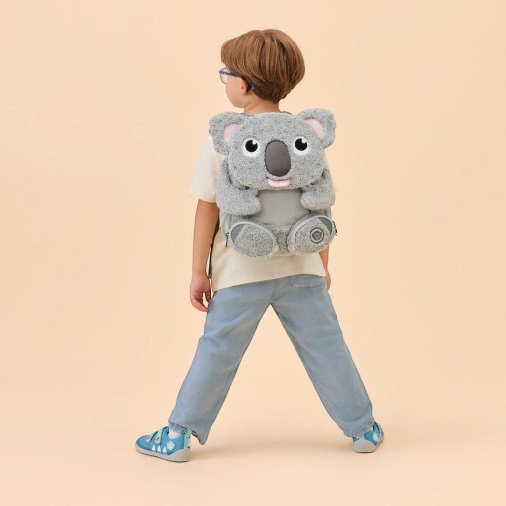 Child wearing a grey plush koala backpack from Lieblingstasche, featuring soft fabric and cute animal design.