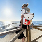 Lieblingstasche Landgang Mini backpack with white sailcloth, red number detail, and brown trim worn by the sea