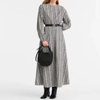 Lieblingstasche Le Foulonné Handtasche S in black leather held by a woman in a patterned maxi dress