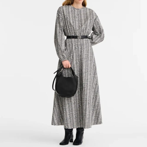 Lieblingstasche Le Foulonné Handtasche S in black leather held by a woman in a patterned maxi dress