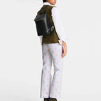 Lieblingstasche Le Foulonné black leather rucksack worn by a model in a white shirt and olive green vest