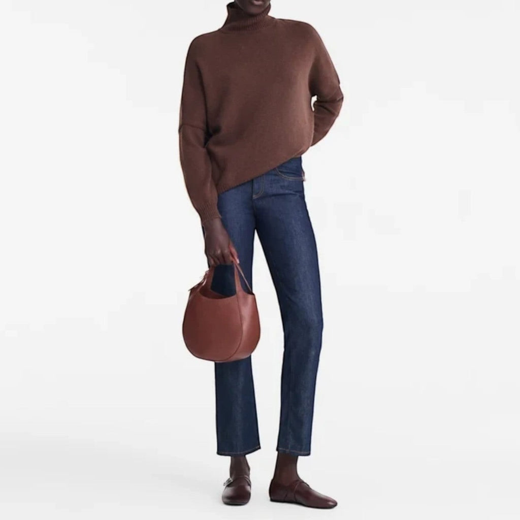 Lieblingstasche Le Foulonné S brown leather hobo bag held by a model wearing a brown turtleneck and dark blue jeans