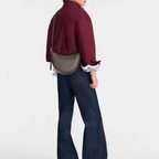 Lieblingstasche Le Foulonné Umhängetasche S in grey leather worn as a crossbody bag by a model in a burgundy jacket