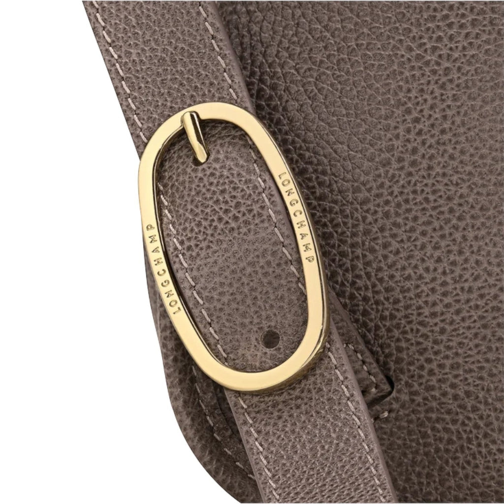 Lieblingstasche Le Foulonné Rucksack in taupe textured leather with gold buckle detail and white stitching.