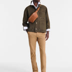 Lieblingstasche Le Foulonné tan leather belt bag worn across the chest by a man in an olive jacket and beige trousers