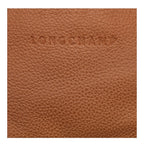 Close-up of tan grained leather texture with embossed Longchamp logo from Lieblingstasche Le Foulonné belt bag