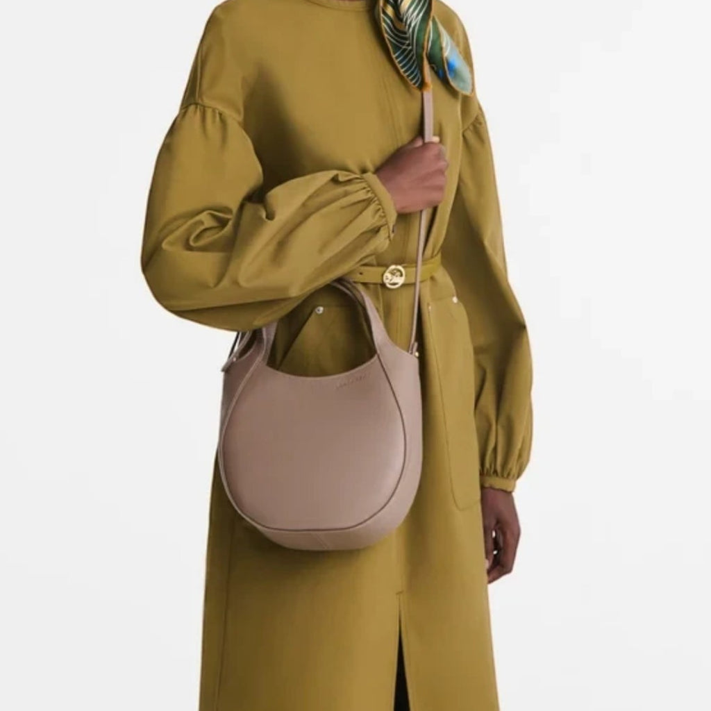 Lieblingstasche Le Foulonné Handtasche S in taupe leather worn as a crossbody bag by a model in an olive dress