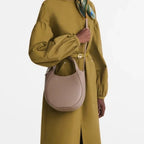 Lieblingstasche Le Foulonné Handtasche S in taupe leather worn as a crossbody bag by a model in an olive dress