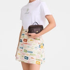Lieblingstasche Le Panier Pliage XS dark brown woven crossbody bag with top handle.