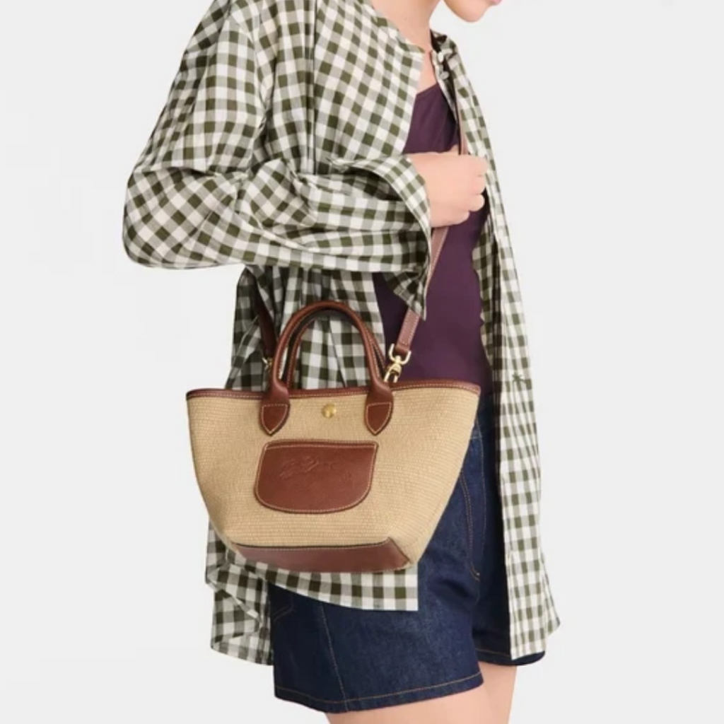 Lieblingstasche Le Panier Pliage XS straw-effect crossbody bag with brown leather trim worn by a model