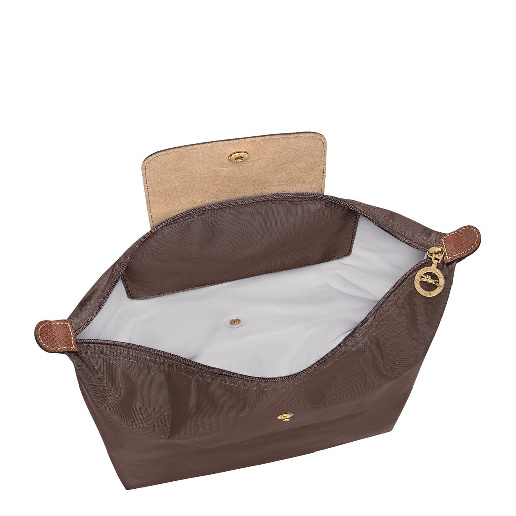 Lieblingstasche Le Pliage rucksack in brown nylon with leather flap, gold hardware, and zipper closure.