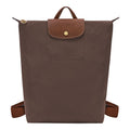 Lieblingstasche Le Pliage brown nylon rucksack with a textured leather flap and gold-tone snap button closure.