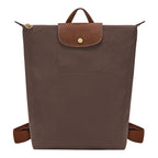 Lieblingstasche Le Pliage brown nylon rucksack with a textured leather flap and gold-tone snap button closure.