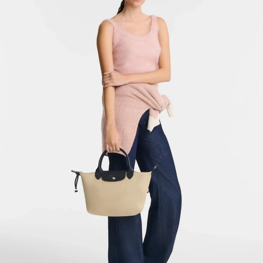 Lieblingstasche Le Pliage Energy S handbag in beige recycled nylon with black handles and rope detail held by model