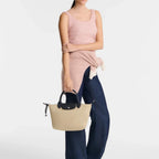 Lieblingstasche Le Pliage Energy S handbag in beige recycled nylon with black handles and rope detail held by model