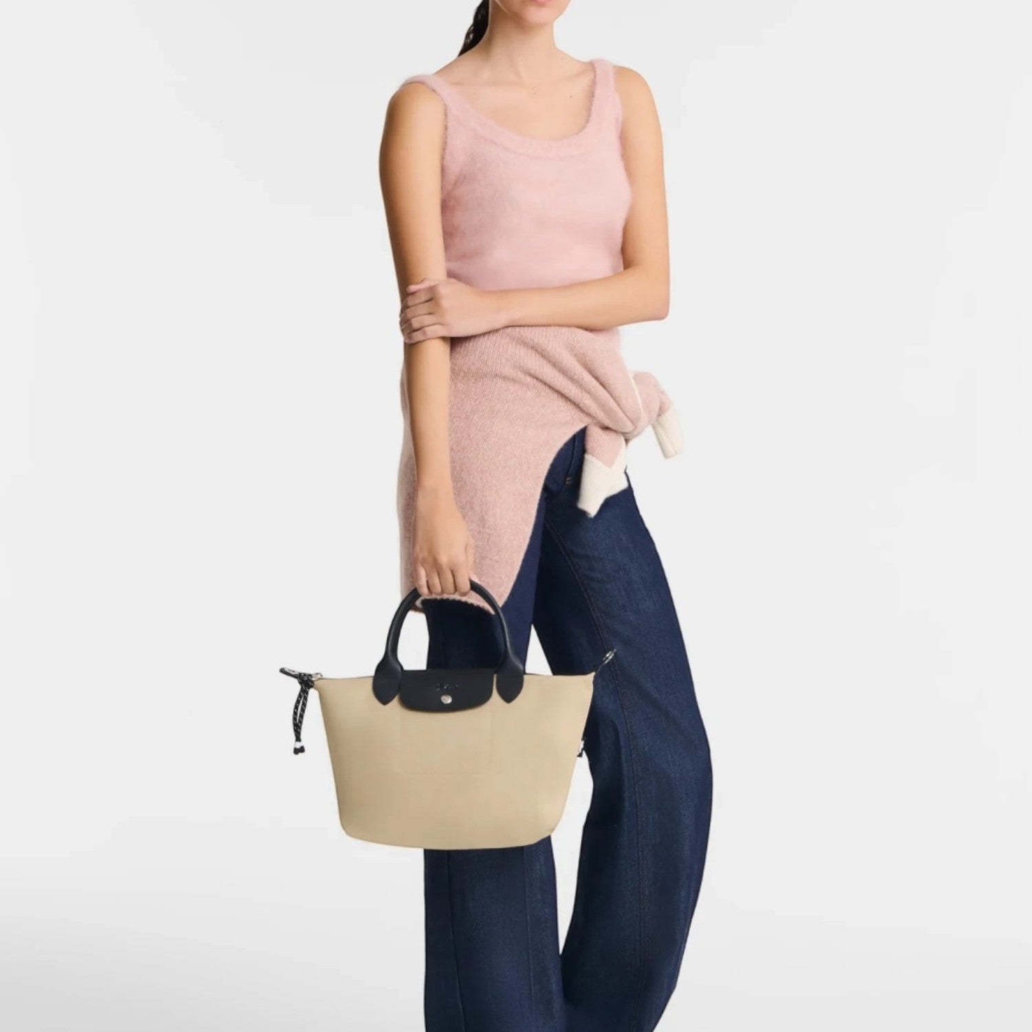 Lieblingstasche Le Pliage Energy S handbag in beige recycled nylon with black handles and rope detail held by model