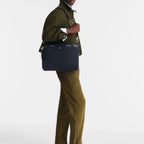 Lieblingstasche Le Pliage Energy black business bag carried by a man wearing an olive green jacket and trousers