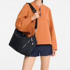 Model wearing a black Lieblingstasche Le Pliage Energy medium crossbody bag with an adjustable strap