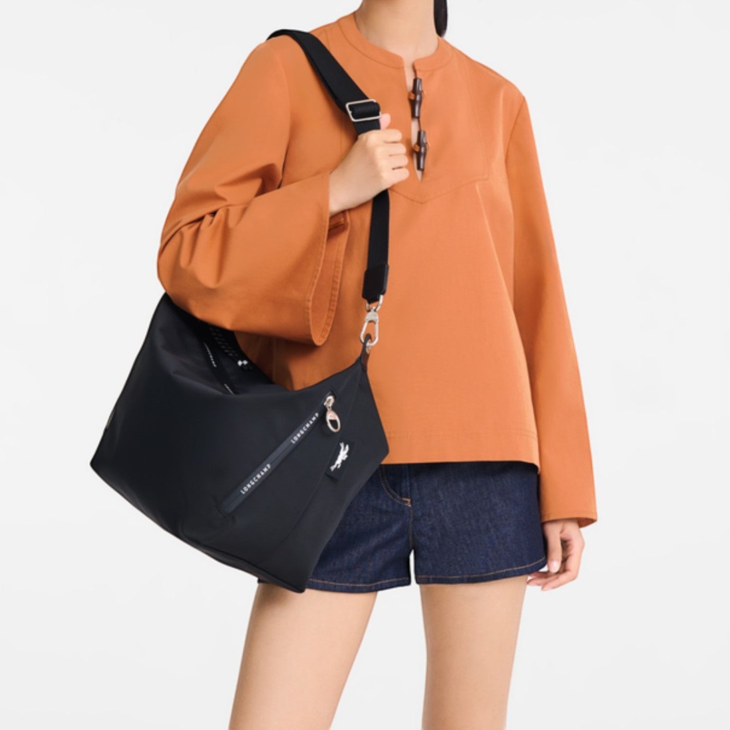 Model wearing a black Lieblingstasche Le Pliage Energy medium crossbody bag with an adjustable strap