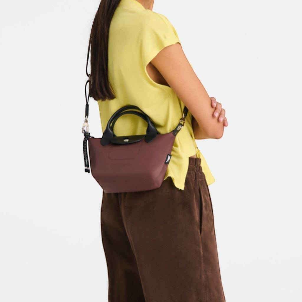Lieblingstasche Le Pliage Energy XS handbag in brown recycled nylon with black handles and rope detail worn by model