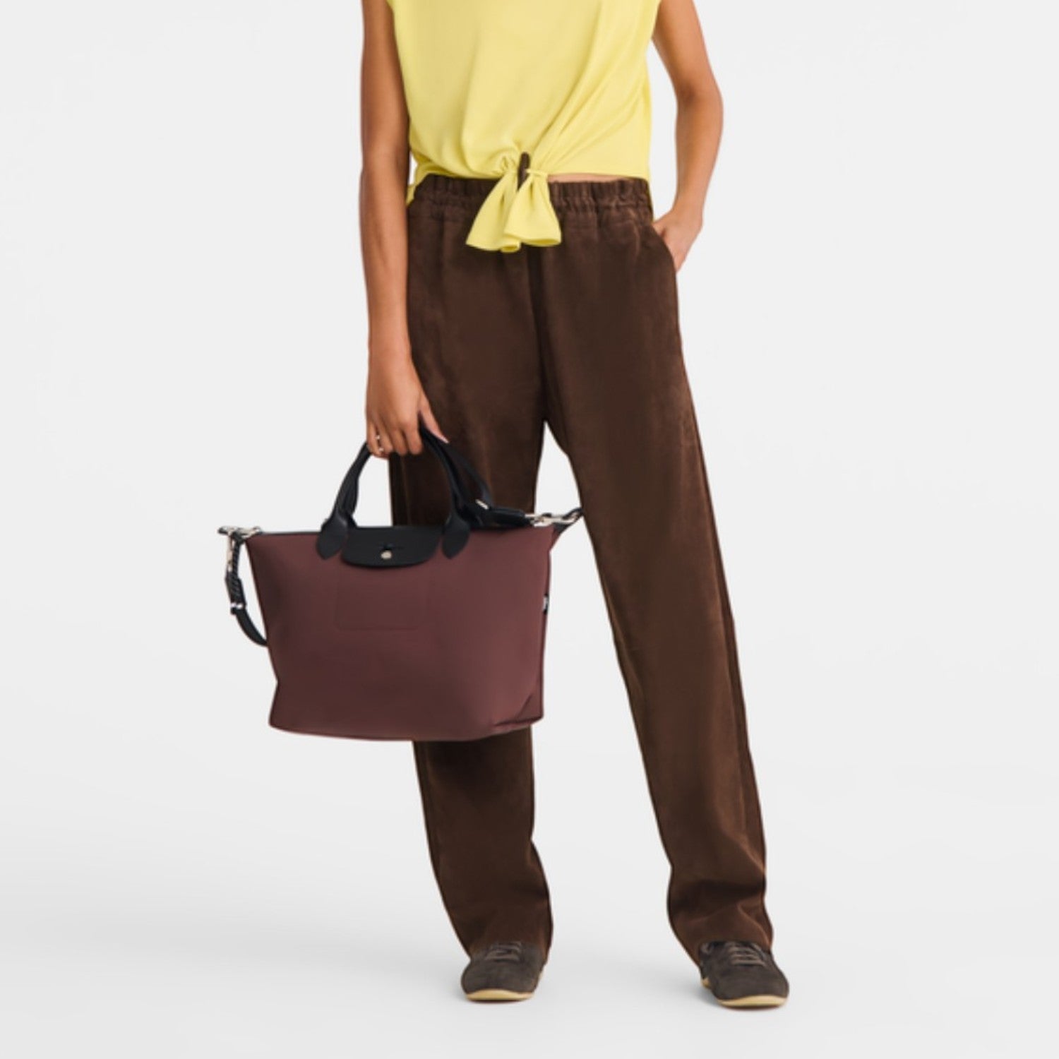 Lieblingstasche Le Pliage Energy medium handbag in burgundy recycled nylon with black rope detail held by a model