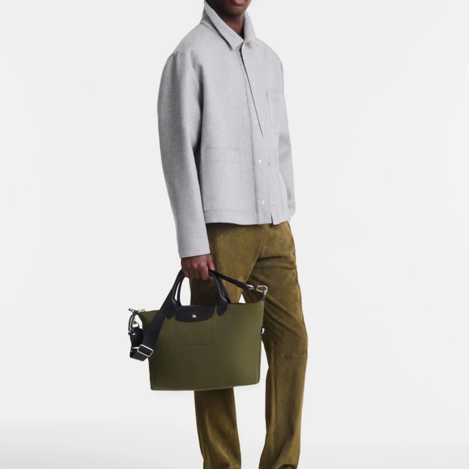 Lieblingstasche Le Pliage Energy olive green recycled nylon handbag with black rope details held by a male model
