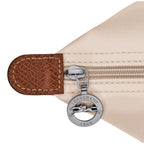 Lieblingstasche Le Pliage L handbag in beige nylon with leather trim and a silver zipper pull featuring the Longchamp logo.