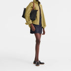 Lieblingstasche Le Pliage L black nylon tote bag with brown leather straps worn by a model.