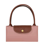 Lieblingstasche Le Pliage L handbag in pink nylon with brown leather trim and handles. Features a snap closure.