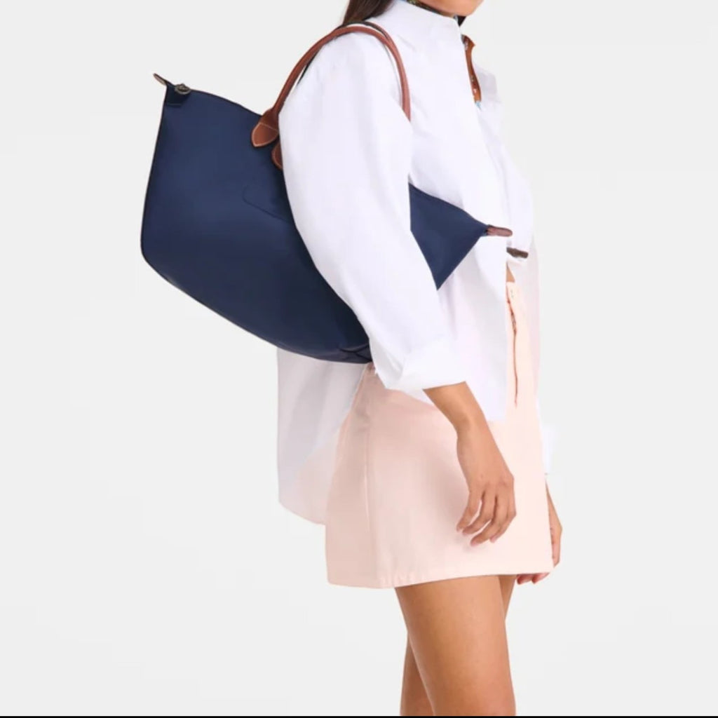 Lieblingstasche Le Pliage L navy nylon tote bag with brown leather handles worn by a model