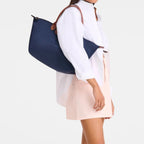 Lieblingstasche Le Pliage L navy nylon tote bag with brown leather handles worn by a model