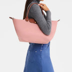 Lieblingstasche Le Pliage L pink nylon tote bag with brown leather handles and trim.