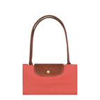 Lieblingstasche Le Pliage M shoulder bag in coral nylon with brown leather trim and handles.