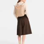 Lieblingstasche Le Pliage One beige rucksack worn on the back by a woman in a cream sweater and brown culottes