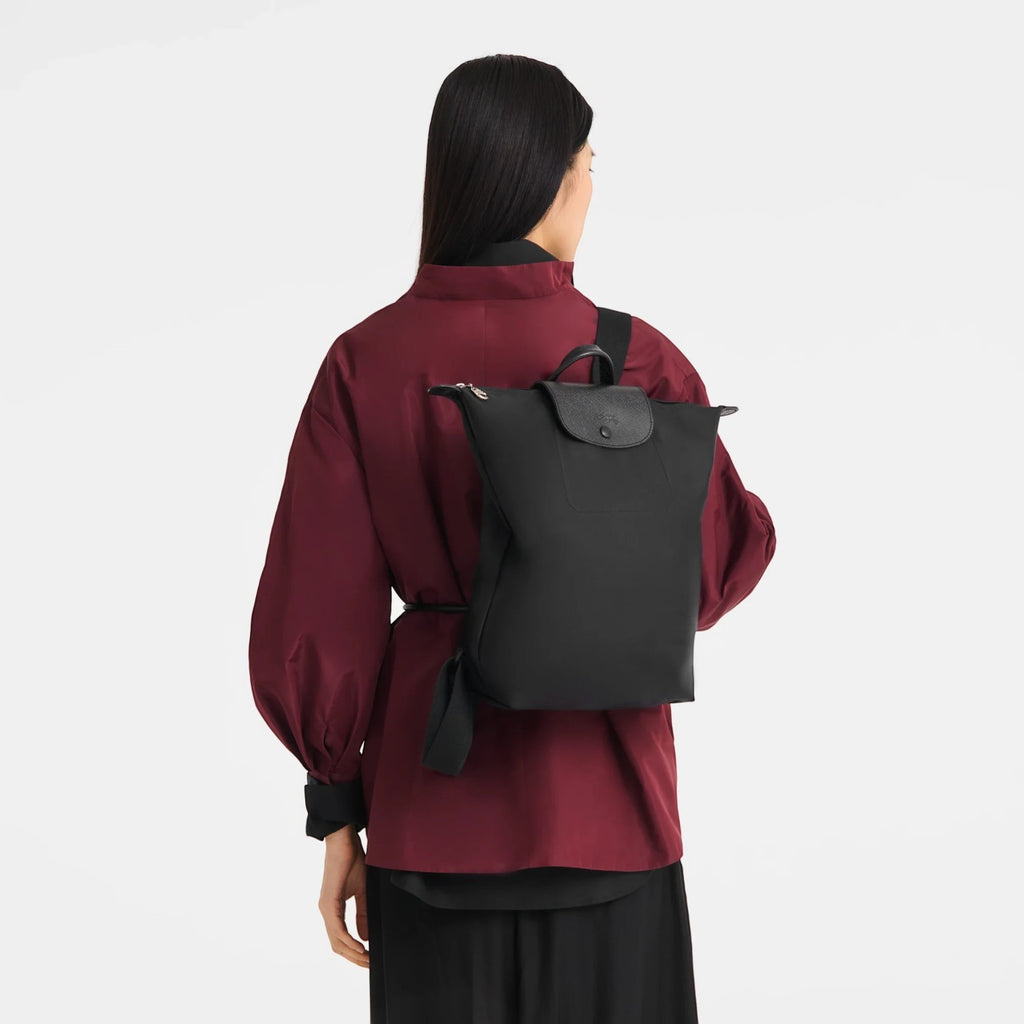 Lieblingstasche Le Pliage One black nylon rucksack worn on the back by a woman in a burgundy jacket