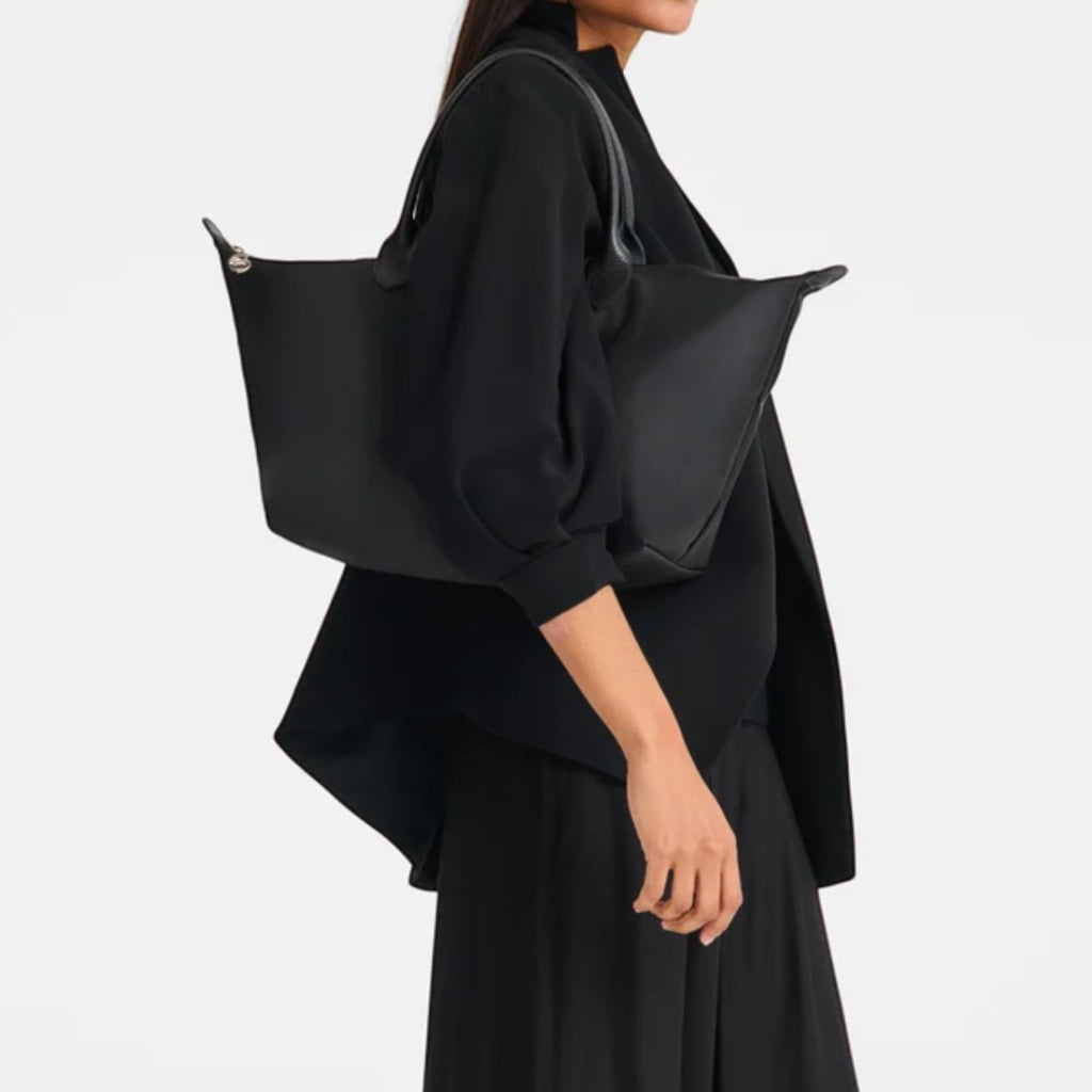 Lieblingstasche Le Pliage One black nylon tote bag with leather handles, worn by a model.